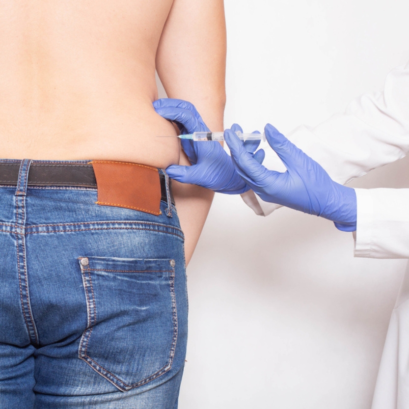 Man receiving abdominal injection from medical provider